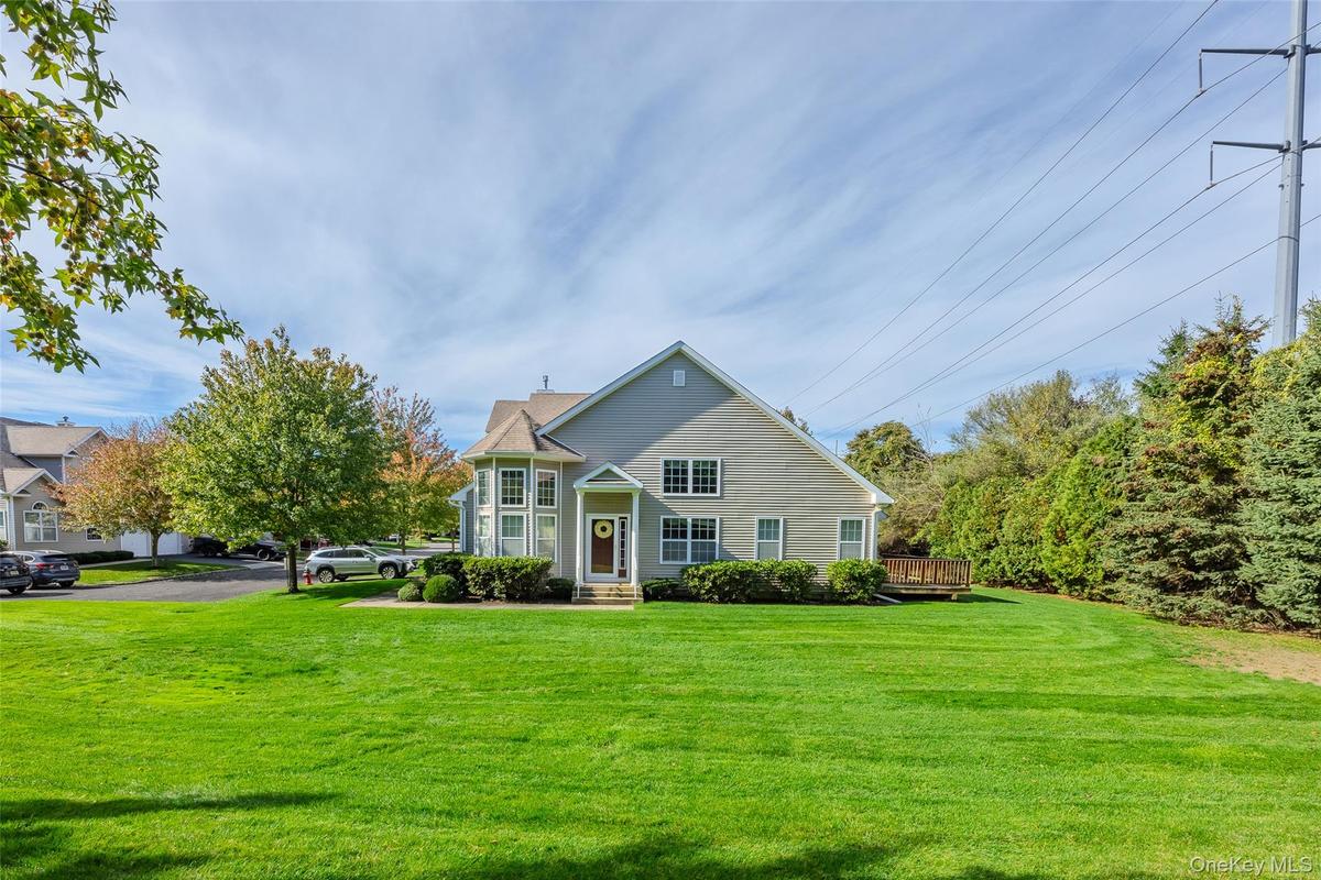 View of front of property with a front yard and a deck