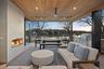 Patio terrace at dusk featuring an outdoor living space with a fireplace, ceiling fan, exterior kitchen, and a grill