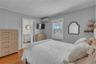 Bedroom with crown molding, wood finished floors, a wall mounted air conditioner, and ensuite bath