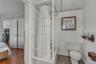Full bathroom with toilet and wainscoting