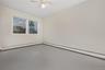 Spare room with a baseboard heating unit and a ceiling fan