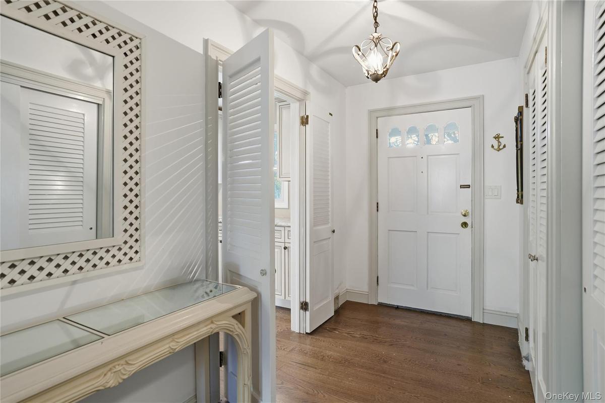 Entryway featuring dark wood-style flooring and a chandelier