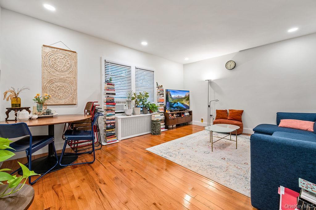Living area with light wood-style flooring and recessed lighting