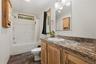 Bathroom featuring a full vanity with an integrated sink, a large mirror, and a three-light fixture