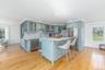 Kitchen featuring appliances with stainless steel finishes, tasteful backsplash, a breakfast bar, a center island, and light stone counters