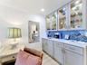 Wet bar and coffee bar with a beautiful backsplash, quartz countertop and glass cabinets with inside lights for added ambiance