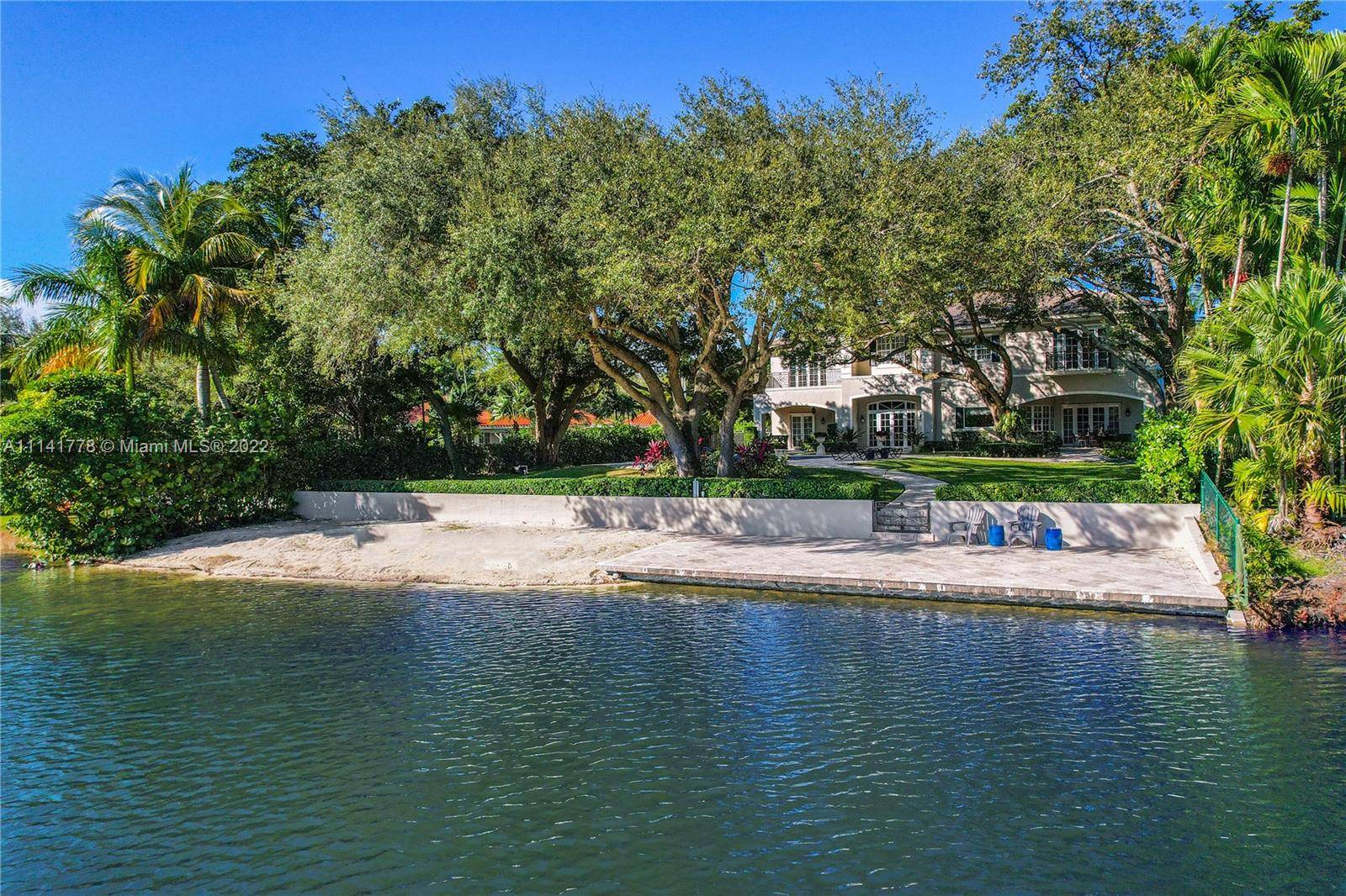 Splendid Hammock Lakes residence sits on a picture perfect lakefront acre w rolling green lawns, private white sand beach spectacular waterfront views.