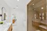 Full bathroom with a stall shower, a soaking tub, double vanity, recessed lighting, and lofted ceiling