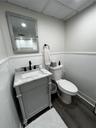 Bathroom featuring dark wood-style flooring, a shower with shower curtain, vanity, and wainscoting