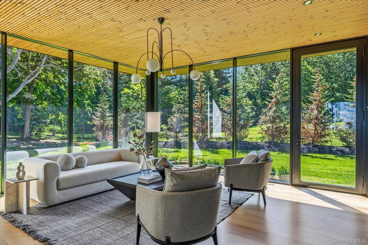 Den with floor to ceiling windows and custom built-ins and outdoor access.