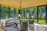 Den with floor to ceiling windows and custom built-ins and outdoor access.