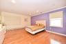 Bedroom featuring baseboard heating, crown molding, and light wood-type flooring