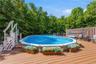 Expansive outdoor deck featuring an above-ground pool with integrated entry steps