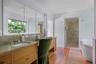 Spa-inspired bathroom with double vanity, oversized walk-in shower, and soaking tub with views over the gardens