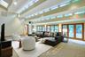 The extraordinary double-height family room showcases soaring ceilings, walls of glass, and seamless indoor-outdoor living.