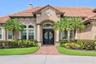 Stunning front elevation with a grand entry, mature landscaping, and timeless architectural detail.