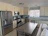 Kitchen with a sink, backsplash, visible vents, and appliances with stainless steel finishes