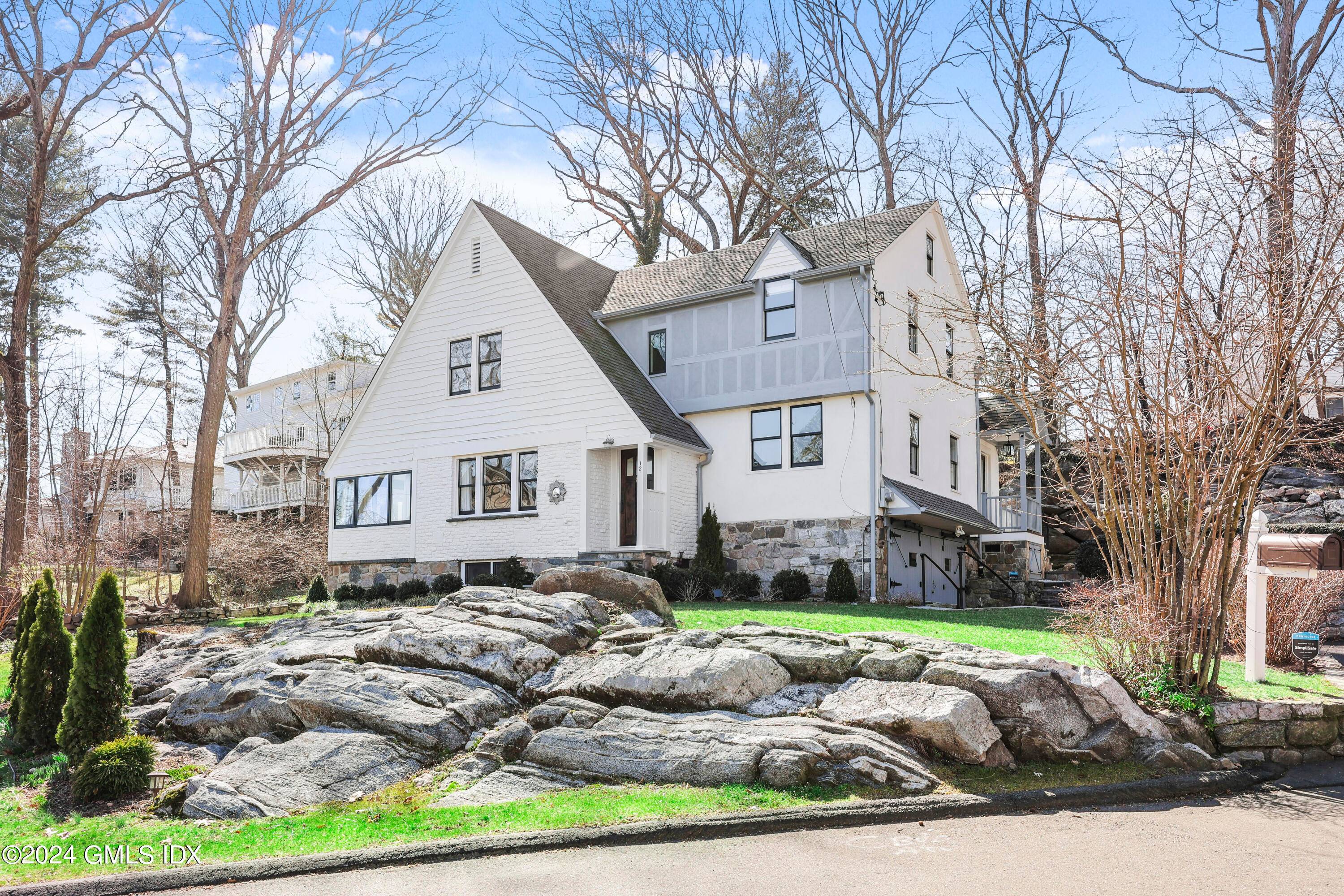 Stylish three bedroom Tudor sits atop an exquisitely landscaped property with entertaining terraces and decks in desirable Cos Cob neighborhood near schools, shops and park.
