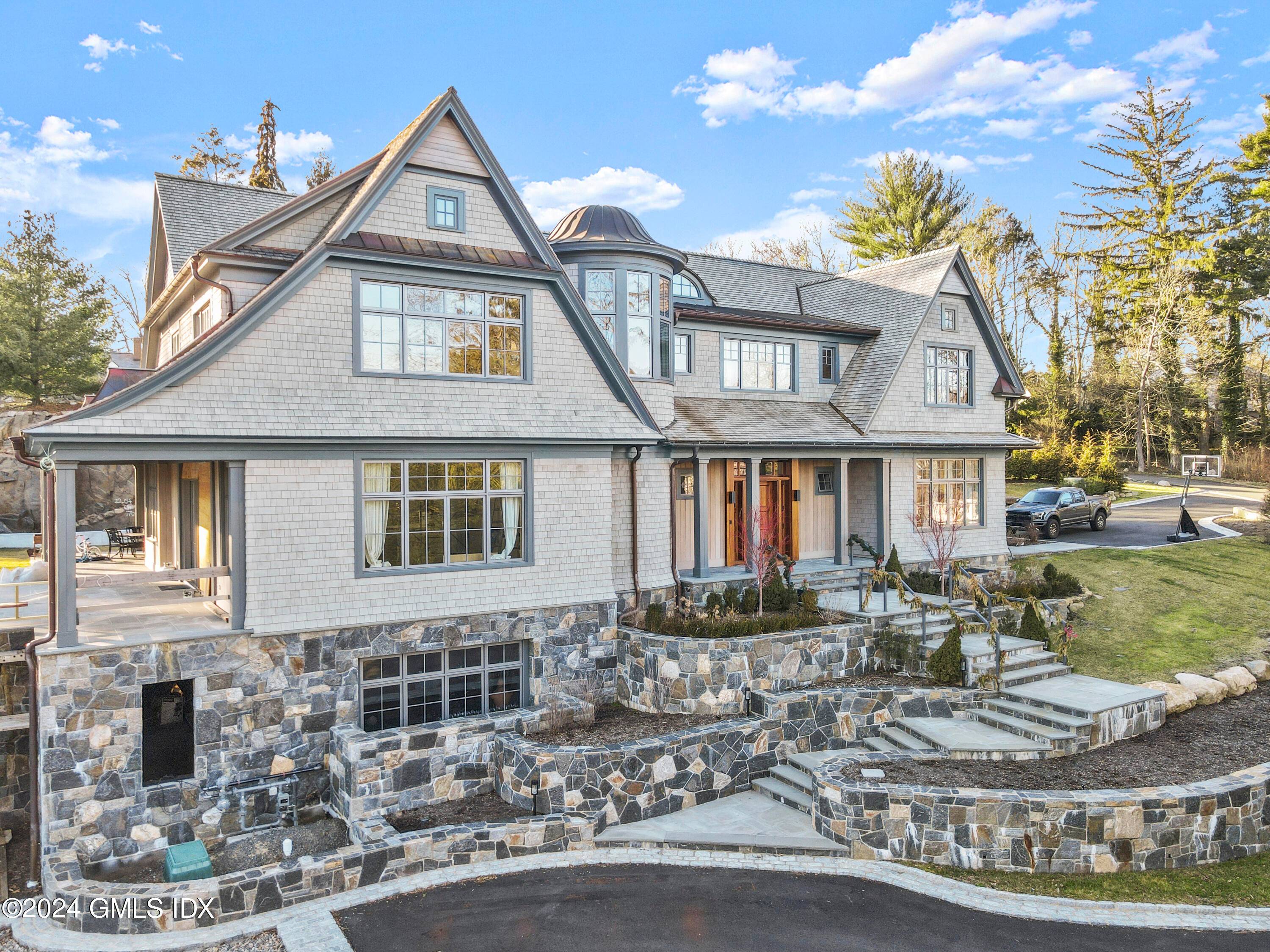 Masterfully crafted, newly built Shingle Style Coastal home sits atop.