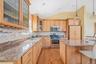 Kitchen with decorative backsplash, a breakfast bar, stainless steel appliances, light wood-style floors, and vaulted ceiling