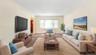 Living area with carpet flooring, arched walkways, and radiator heating unit