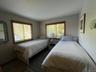 Bedroom with dark wood-style flooring and baseboards