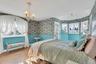 Bedroom featuring wallpapered walls, hardwood / wood-style floors, and a chandelier 2 walk in closets