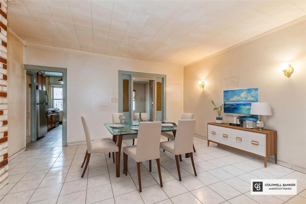 Dining space featuring crown molding and light tile patterned floors