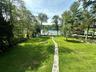 View of home's community featuring a fenced backyard, a water view, and a shed