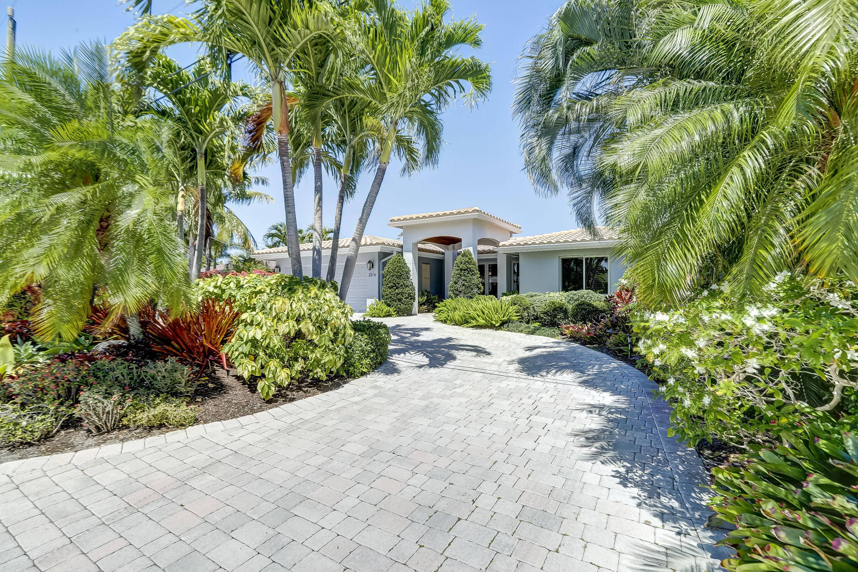 Coral Point Gem ! Beautifully landscaped home with Circular Drive on 70 Feet of Waterfront with dock and a Back Yard Oasis !