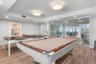 The recreation room hosts a pool table and table tennis area