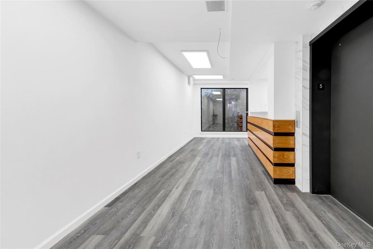 Spare room featuring a skylight, elevator, and wood finished floors
