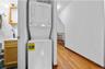 Laundry area featuring wood-type flooring and stacked washer and clothes dryer