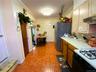 Kitchen with crown molding, light countertops, white gas range, freestanding refrigerator, and under cabinet range hood