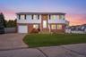 Split foyer home featuring concrete driveway, brick siding, and a garage