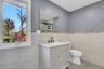 Bathroom featuring vanity, tile walls, a stall shower, and light tile patterned floors