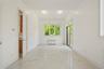 Empty room with beamed ceiling, light marble finish floors, and radiator heating unit