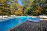 View of pool featuring a patio area, a diving board, and a pool with connected hot tub