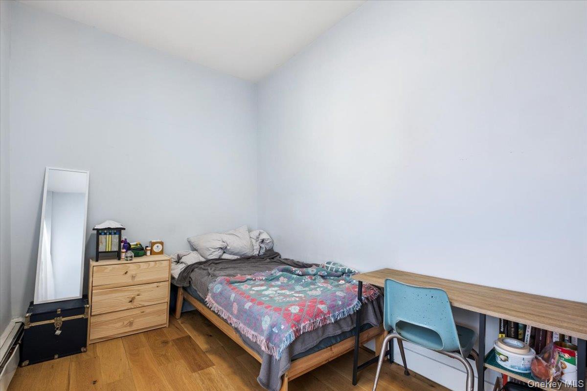1st Floor Apartment bedroom features light-colored walls and hardwood flooring, providing a neutral canvas