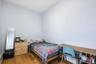 1st Floor Apartment bedroom features light-colored walls and hardwood flooring, providing a neutral canvas