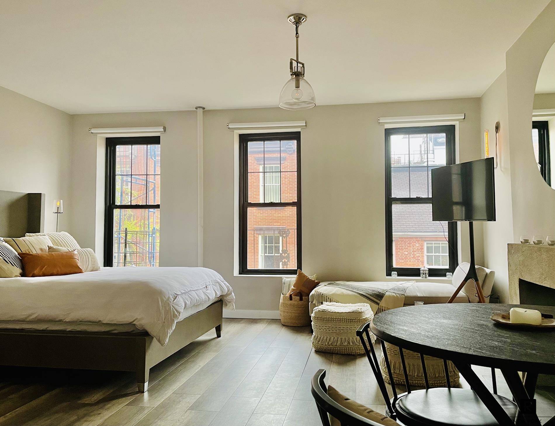 This stunning, large studio was recently renovated with luxurious finishes grey oak floors, warm incandescent light fixtures, a decorative fireplace, and motorized blinds.