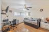 Bedroom with an office area, light wood-style flooring, a ceiling fan, and baseboard heating