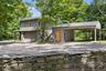 Detached garage with one-bedroom apartment above, covered carport, and EV charging station