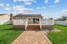 Rear view of house featuring a fenced backyard, a wooden deck, and roof with shingles