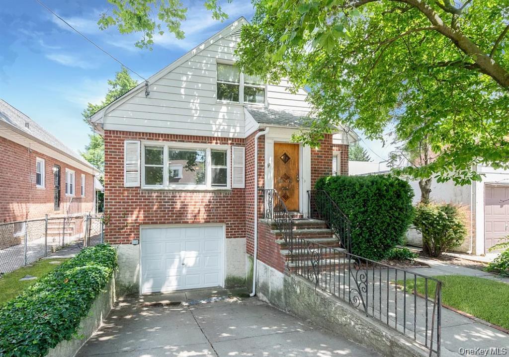 Bungalow with brick siding, concrete driveway, an attached garage, and a gate