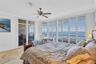 Primary Bedroom with access to the East Bay View Balcony and Travertine Floors and plantation Shutters