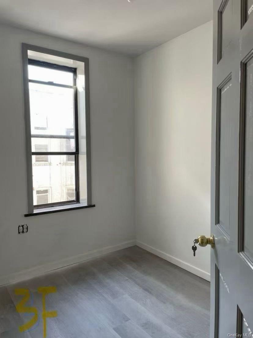 Spare room with baseboards and light wood-type flooring