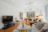Living room featuring beamed ceiling, high vaulted ceiling, light hardwood / wood-style flooring, and ceiling fan