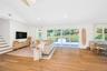 Living area featuring lofted ceiling, light wood-style flooring, stairs, and recessed lighting