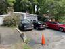 View of parking / parking lot with an attached garage and view of scattered trees